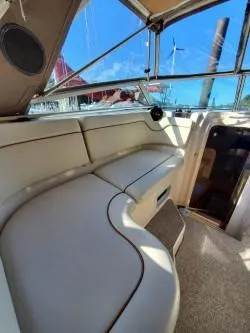Slide: The Image of 2006 Rinker 300 Express Cruiser interior with beige seating and clear windows. - 6