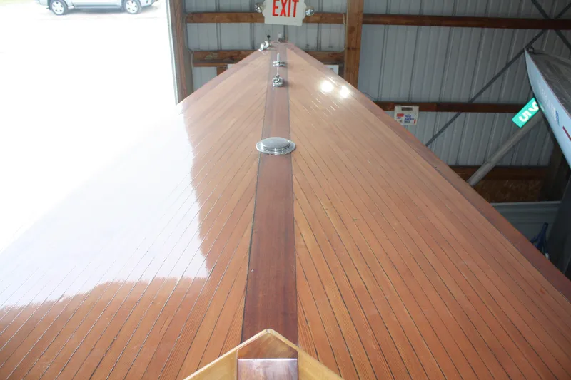 Slide: The Image of 1934 Custom Northern Michigan NM boat with polished wooden deck in storage. - 19