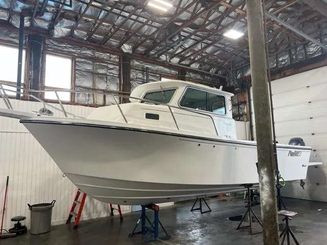 The Image of 2024 Parker 2520 XLD Sport Cabin boat in a warehouse. - 0