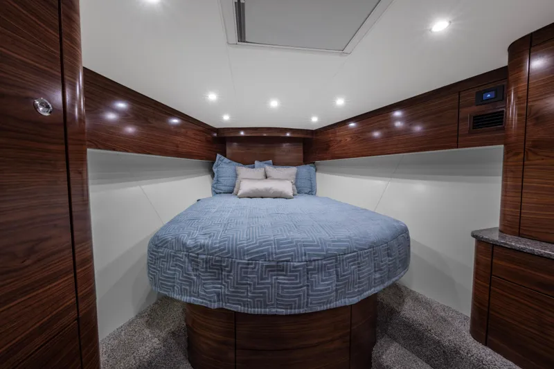Slide: The Image of 2024 Albemarle Spencer Edition boat cabin with round bed and modern wood finish. - 15