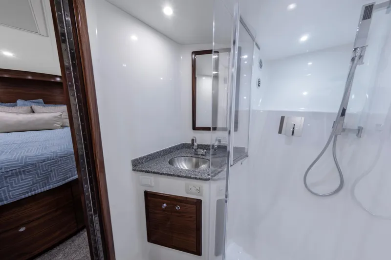 Slide: The Image of 2024 Albemarle Spencer Edition yacht bathroom with sink, mirror, and shower. - 17