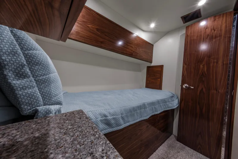 Slide: The Image of 2024 Albemarle Spencer Edition cabin with bed, wooden cabinets, and granite countertop. - 20