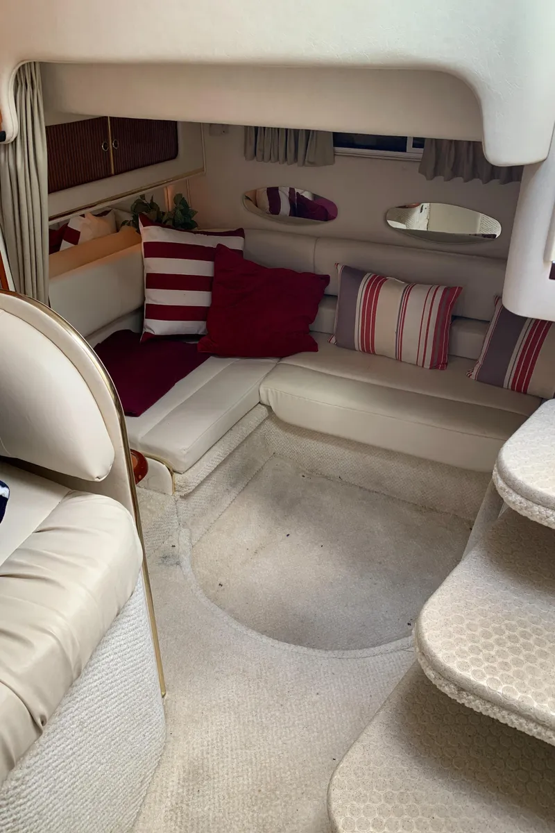 Slide: The Image of Interior of 2001 Sea Ray 310 Sundancer with cozy seating and decorative pillows. - 11