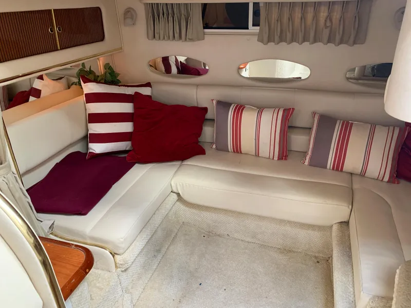 Slide: The Image of Interior of 2001 Sea Ray 310 Sundancer with striped cushions and cozy seating area. - 12