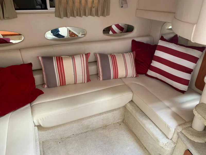 Slide: The Image of 2001 Sea Ray 310 Sundancer interior with striped and solid red cushions on white seating. - 13