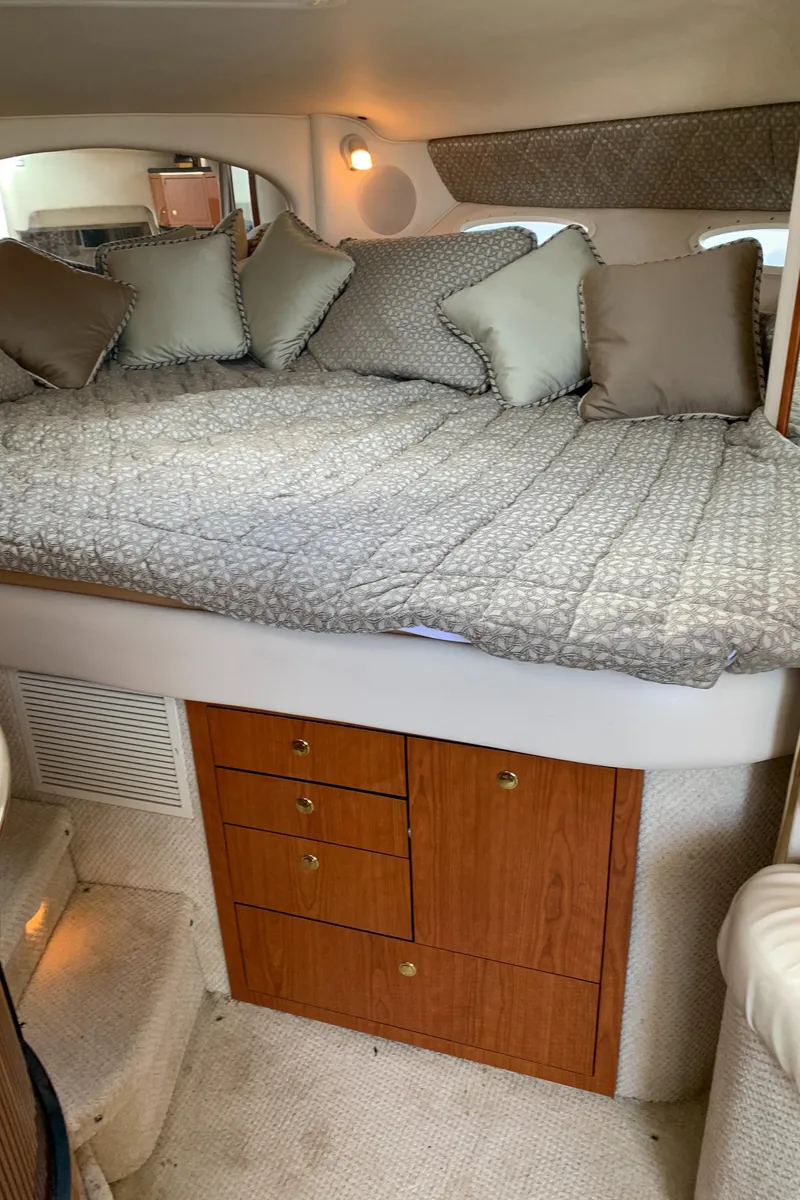 Slide: The Image of Cozy cabin interior of 2001 Sea Ray 310 Sundancer with bed and storage drawers. - 15