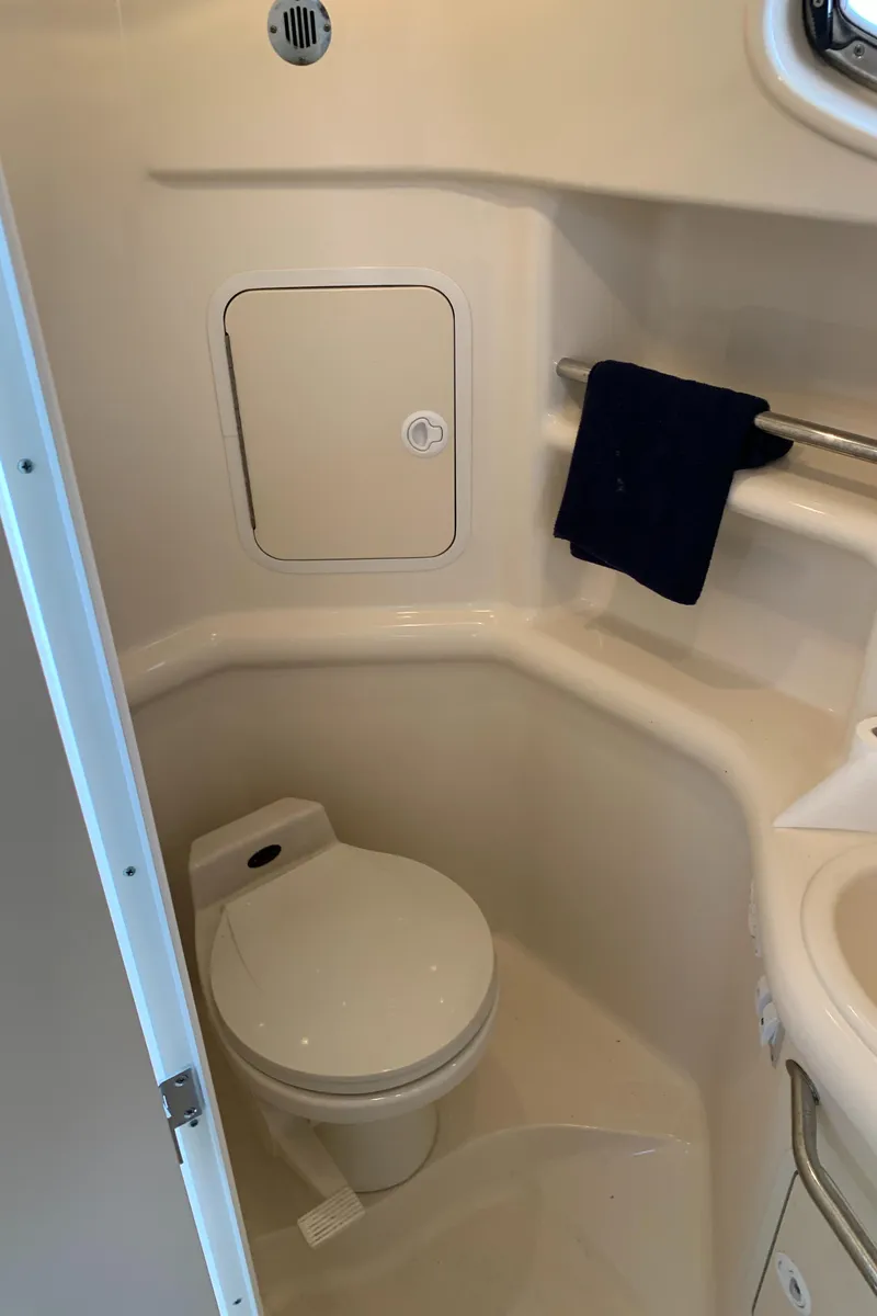 Slide: The Image of 2001 Sea Ray 310 Sundancer bathroom with toilet and storage compartment. - 19