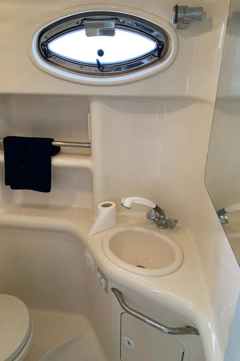 Slide: The Image of 2001 Sea Ray 310 Sundancer bathroom with sink, porthole, and towel rack. - 20