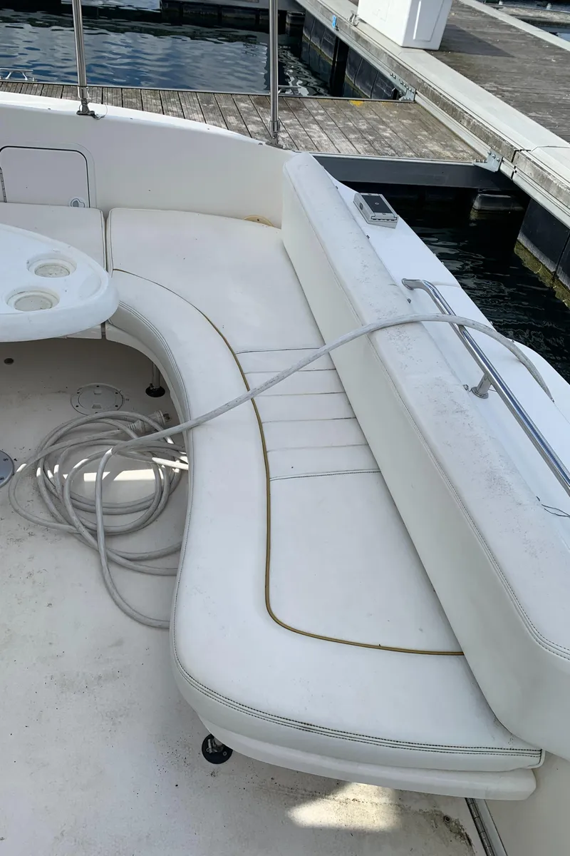 Slide: The Image of 2001 Sea Ray 310 Sundancer boat with white seating and dock view. - 23