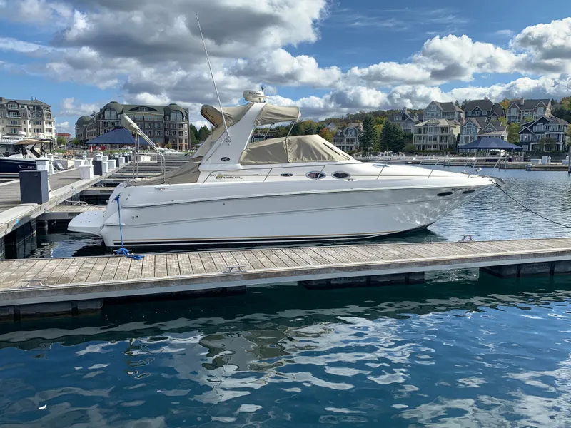 Slide: The Image of 2001 Sea Ray 310 Sundancer docked at a marina under a partly cloudy sky. - 3