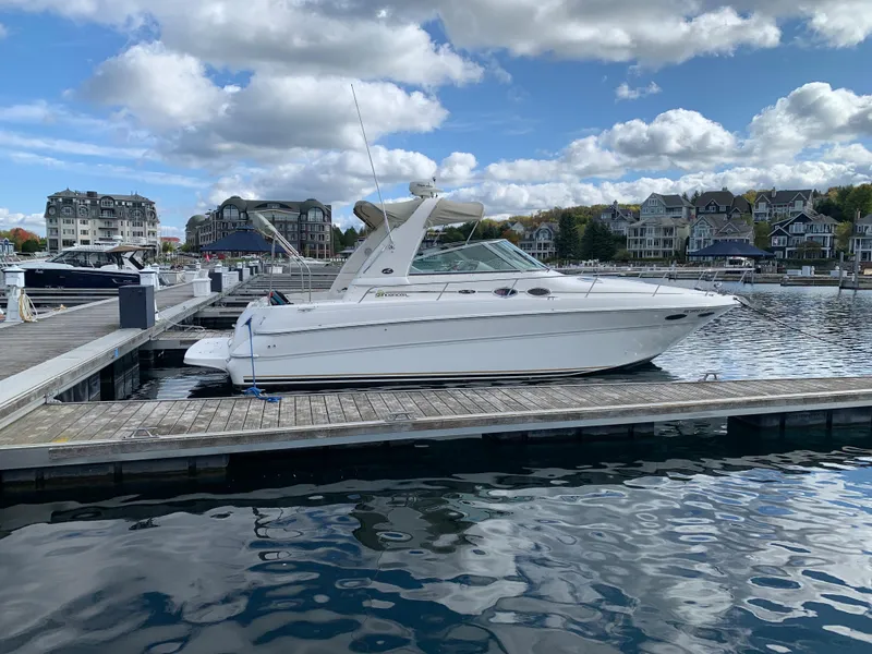 Slide: The Image of 2001 Sea Ray 310 Sundancer docked at a marina under a partly cloudy sky. - 31