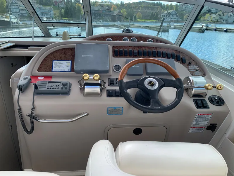 Slide: The Image of 2001 Sea Ray 310 Sundancer helm with steering wheel and navigation controls. - 7
