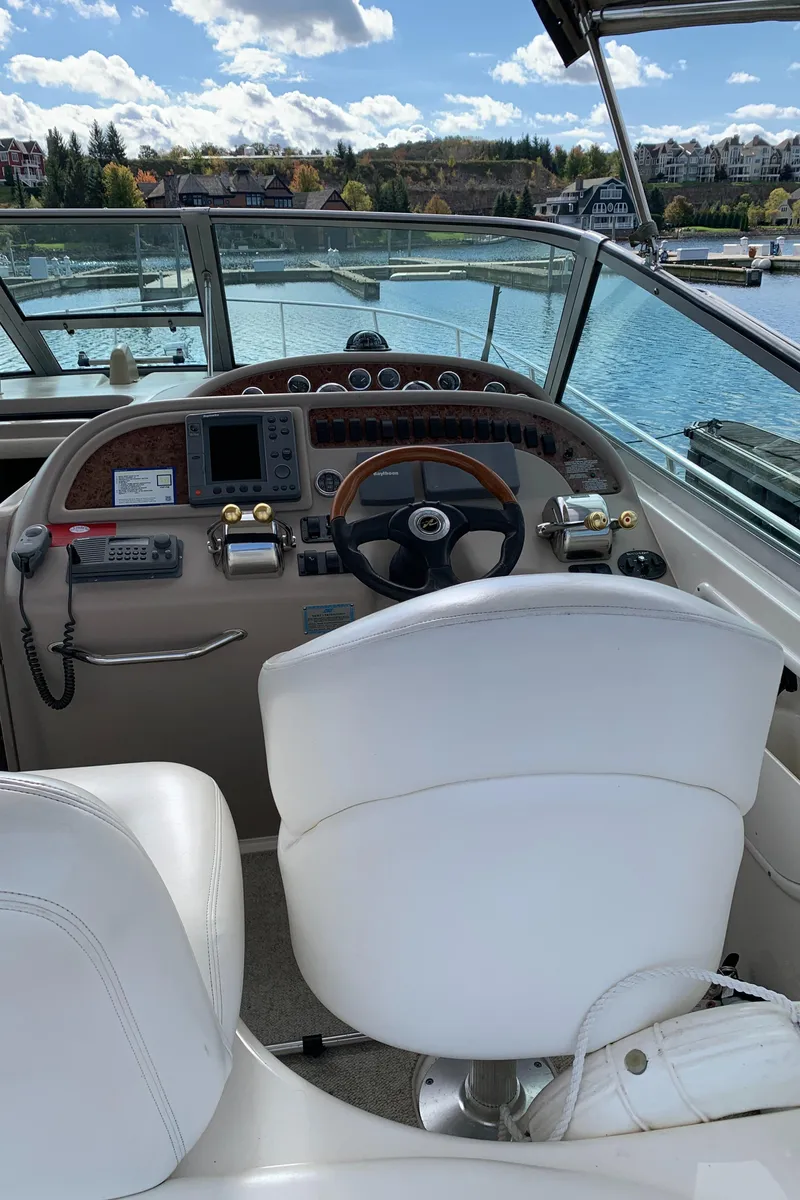 Slide: The Image of 2001 Sea Ray 310 Sundancer helm with scenic waterfront view. - 8