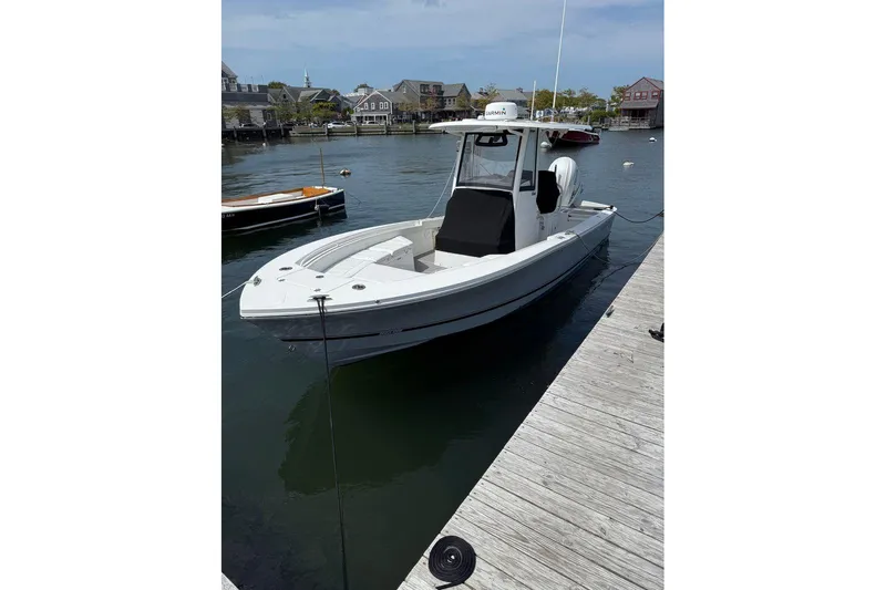 Slide: The Image of 2022 Regulator 26XO boat docked in a marina, showcasing sleek design and modern features. - 1