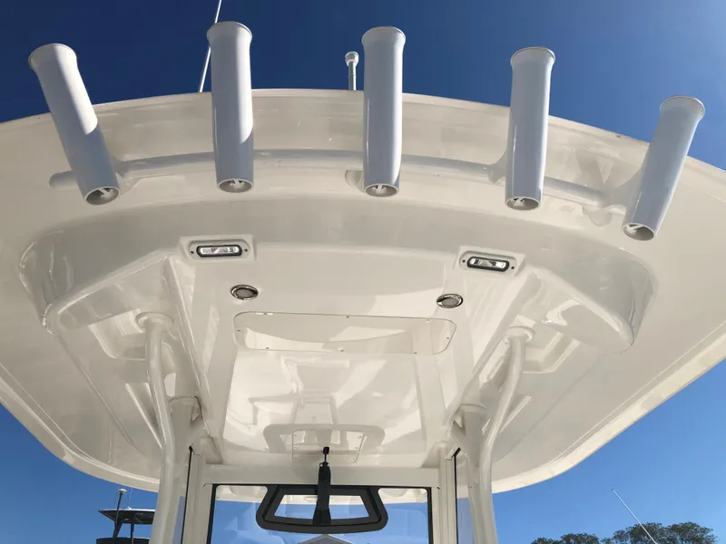 Slide: The Image of 2022 Regulator 26XO boat T-top with rod holders against clear blue sky. - 10