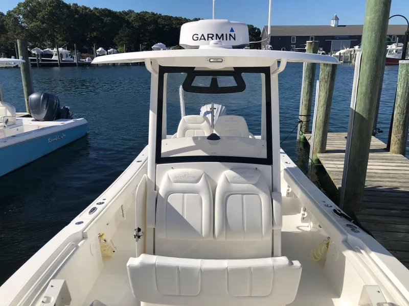 Slide: The Image of 2022 Regulator 26XO boat docked, featuring Garmin equipment and spacious seating. - 11