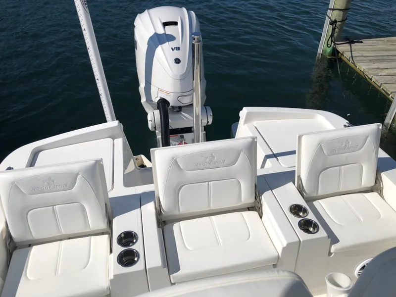 Slide: The Image of 2022 Regulator 26XO boat with white seating and V8 engine, docked by the water. - 12