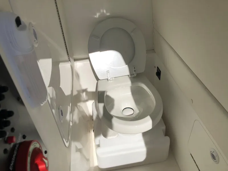Slide: The Image of 2022 Regulator 26XO boat interior with a compact marine toilet. - 15