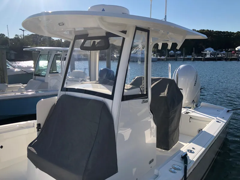 Slide: The Image of 2022 Regulator 26XO boat docked, featuring a sleek design and covered seating area. - 16