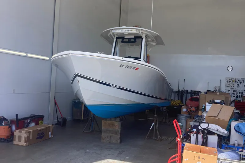 Slide: The Image of 2022 Regulator 26XO boat in a garage, surrounded by tools and equipment. - 2