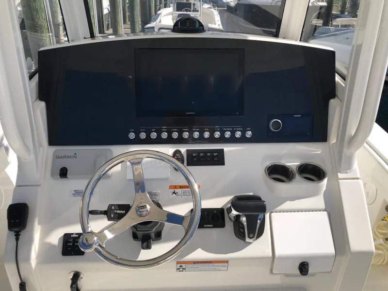 Slide: The Image of 2022 Regulator 26XO boat dashboard with steering wheel and control panel. - 4
