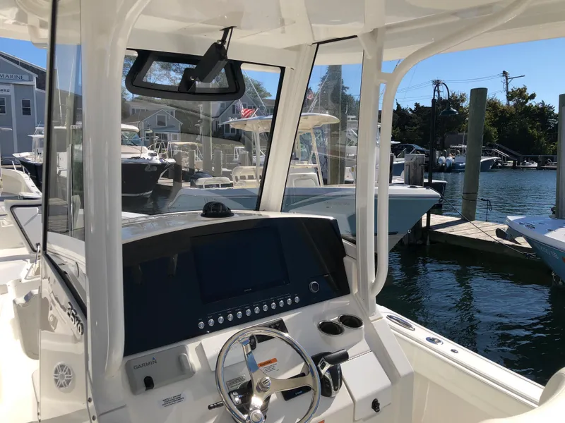 Slide: The Image of 2022 Regulator 26XO boat console with steering wheel, docked at marina. - 9