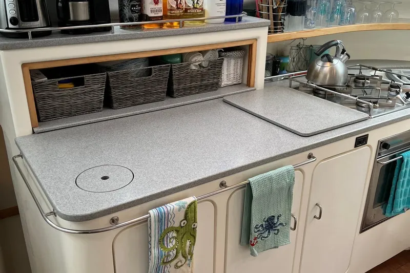 Slide: The Image of Galley kitchen in a 1996 Voyage Yachts 470 with modern appliances and storage baskets. - 14