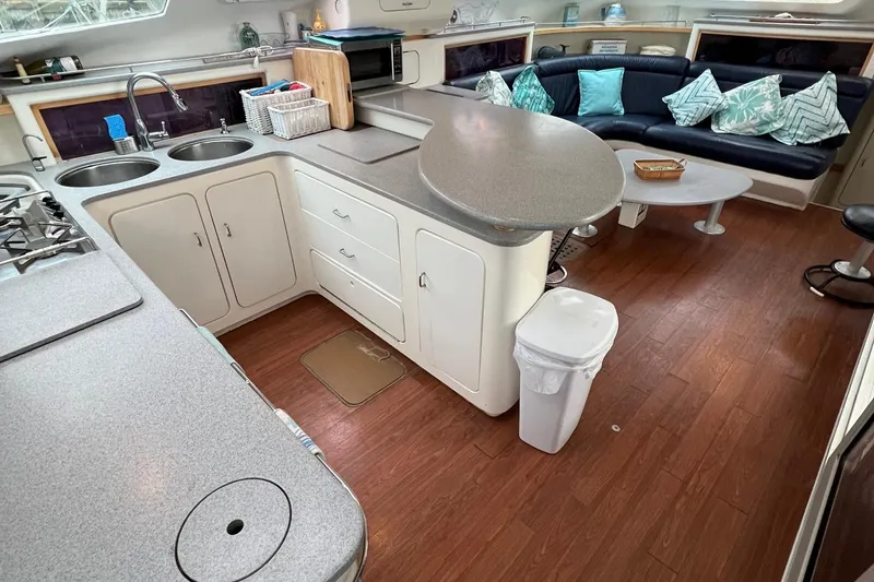 Slide: The Image of 1996 Voyage Yachts 470 interior with kitchen and seating area, modern design, wooden flooring. - 17