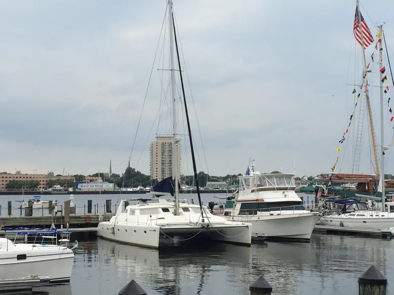 Slide: The Image of 1996 Voyage Yachts 470 catamaran docked at a marina with other boats. - 2
