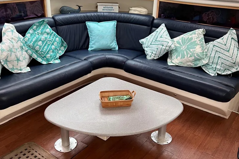 Slide: The Image of Cozy lounge area on a 1996 Voyage Yachts 470 with decorative pillows and a modern table. - 24