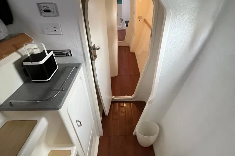 Slide: The Image of Interior of 1996 Voyage Yachts 470, featuring wooden flooring and compact kitchen area. - 28
