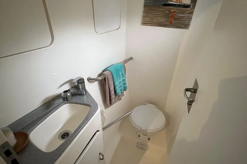 Slide: The Image of Compact bathroom in a 1996 Voyage Yachts 470, featuring a sink, toilet, and towel rack. - 45