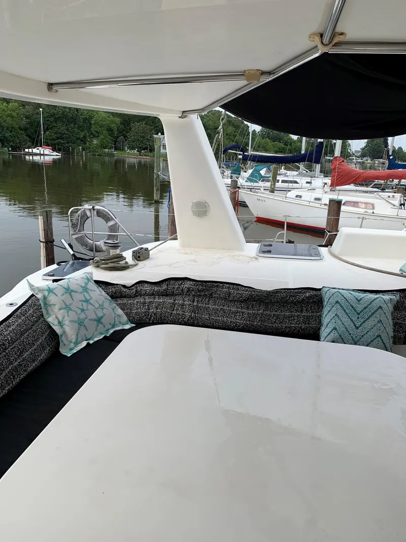 Slide: The Image of Deck of 1996 Voyage Yachts 470 with seating area and marina view. - 7