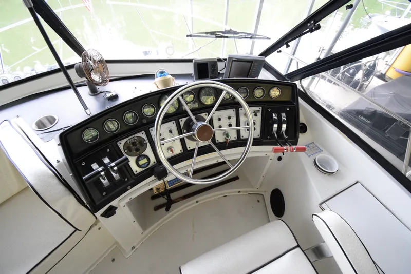 Slide: The Image of 1989 Carver 32 Mariner helm with steering wheel, gauges, and controls. - 12