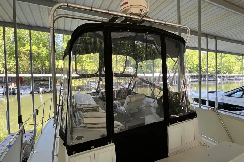 Slide: The Image of 1989 Carver 32 Mariner boat docked under a covered marina with clear enclosure. - 15