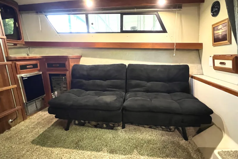 Slide: The Image of Interior of 1989 Carver 32 Mariner with black seating and wood accents. - 19