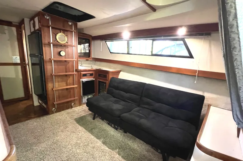 Slide: The Image of Interior of 1989 Carver 32 Mariner yacht with black sofa and kitchenette. - 23