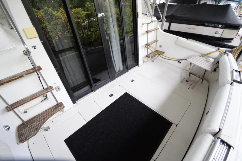 Slide: The Image of 1989 Carver 32 Mariner boat deck with seating, ladder, and sliding glass doors. - 28