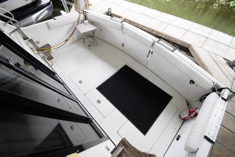Slide: The Image of 1989 Carver 32 Mariner boat deck with seating, docked by the water. - 29