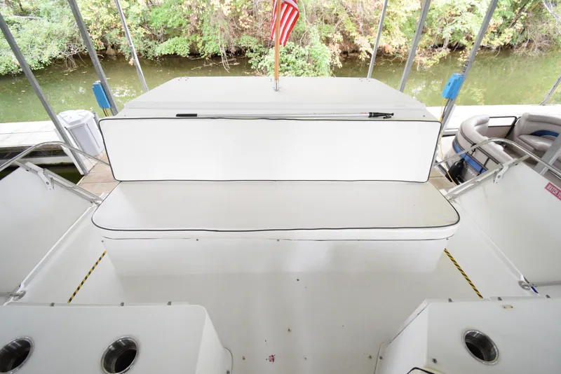 Slide: The Image of 1989 Carver 32 Mariner boat interior with white seating and American flag. - 7