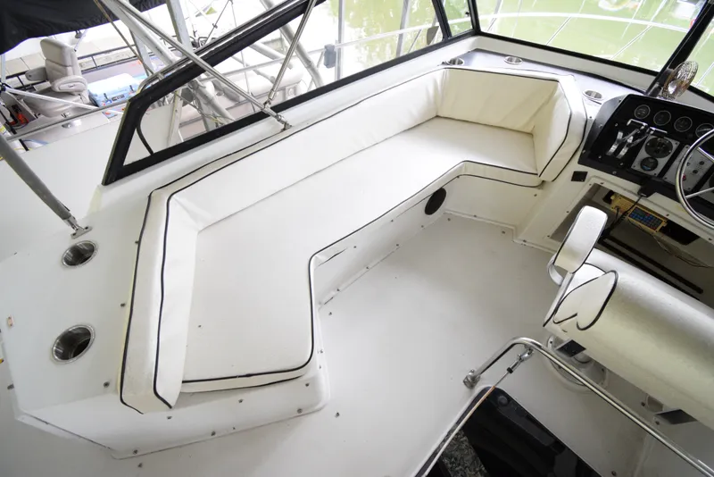 Slide: The Image of 1989 Carver 32 Mariner cockpit with white seating and steering console. - 8
