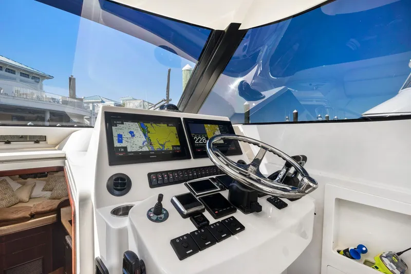 Slide: The Image of 2017 Jupiter 41SB boat helm with navigation screens and steering wheel. - 6