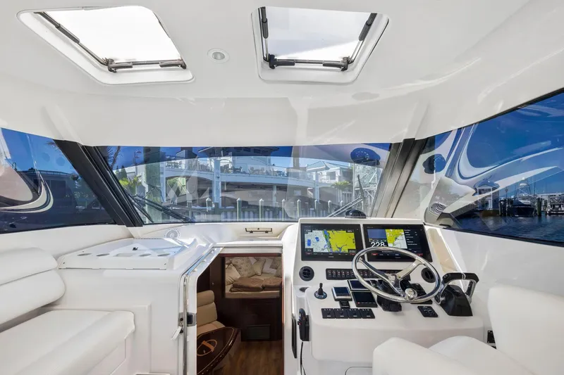 Slide: The Image of Interior cockpit of 2017 Jupiter 41SB boat with navigation screens and steering wheel. - 8