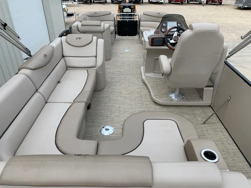 Slide: The Image of 2015 Avalon Ambassador Rear J Lounge boat interior with beige seating and steering console. - 10