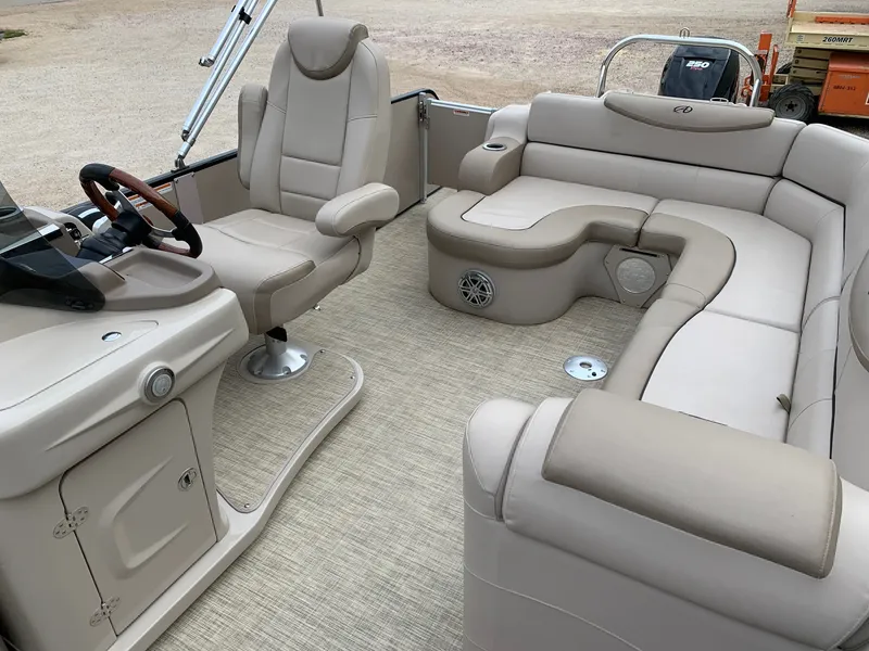 Slide: The Image of 2015 Avalon Ambassador Rear J Lounge boat interior with beige seating and steering console. - 16