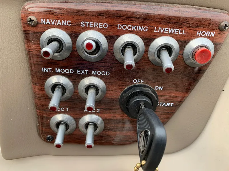 Slide: The Image of Control panel of a 2015 Avalon Ambassador boat with various switches and key ignition. - 20