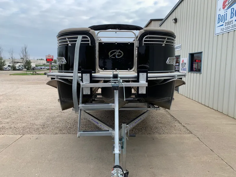 Slide: The Image of 2015 Avalon Ambassador Rear J Lounge 25' pontoon boat on trailer, parked outside dealership. - 4