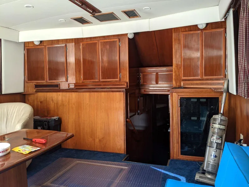 Slide: The Image of Interior of a 1977 Hatteras 46 Convertible yacht with wooden cabinetry and blue carpet. - 10