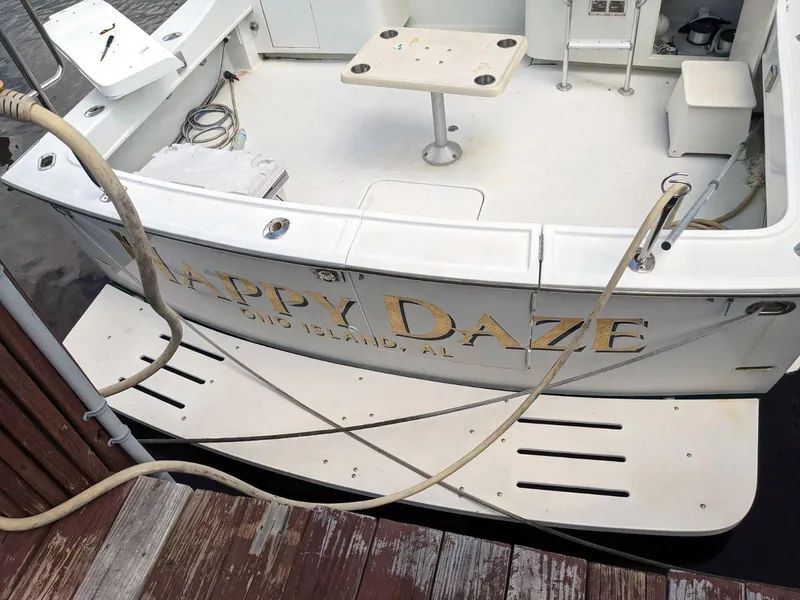 Slide: The Image of 1977 Hatteras 46 Convertible boat named "Happy Daze" docked at a marina. - 31