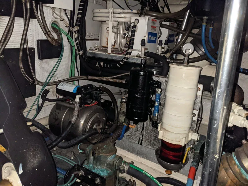 Slide: The Image of Engine room of a 1977 Hatteras 46 Convertible boat, showcasing mechanical components and wiring. - 34